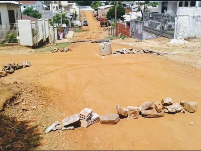 Moradores colocam obstáculos em rua empoeirada