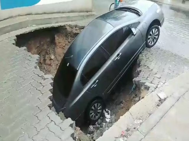 Em Fortaleza, um carro foi engolido por uma cratera durante chuva dois meses aps a concluso de uma obra no local