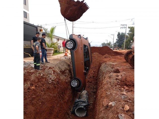 Carro cai em buraco de obra na sada da garagem de prdio